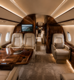 Custom luxury private jet cabin with cream leather seats, wood veneer panels and ambient lighting after VIP interior refurbishment