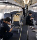 Aviation technicians refurbishing commercial aircraft cabin seats and sidewall panels inside a certified repair station
